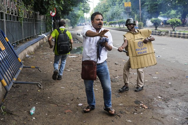 A policeman hits a protester, protesting against the rape and murder of a resident doctor at a government hospital earlier this month, in Kolkata, India, Tuesday, August 27, 2024. (Photo by Bikas Das/AP Photo)