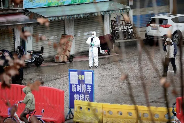 A worker in a protective suit is seen at the closed seafood market in Wuhan, Hubei province, China January 10, 2020. The seafood market is linked to the outbreak of pneumonia caused by the new strain of coronavirus, but some patients diagnosed with the new coronavirus deny exposure to this market. The virus struck as millions of Chinese prepared to travel for the Lunar New Year, heightening contagion risks. Many in China scrambled to buy face masks to protect themselves from the previously unknown, flu-like infection. (Photo by Reuters/China Stringer Network)