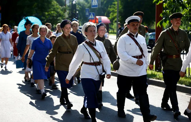 Military enthusiasts dressed as Red Army soldiers and civilians from the World War Two period march as they mark the 75th anniversary of the Nazi Germany invasion, in Brest, Belarus June 21, 2016. (Photo by Vasily Fedosenko/Reuters)