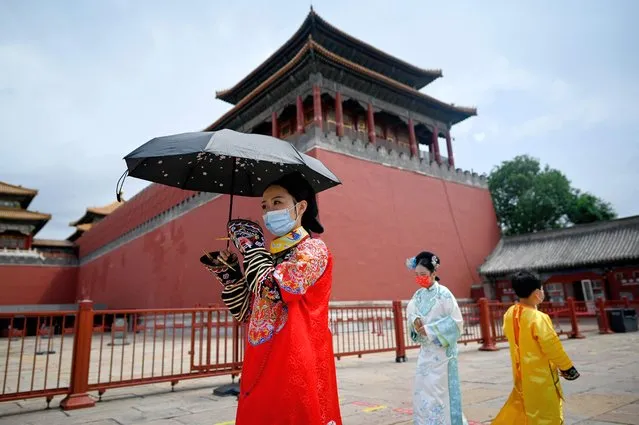 People, wearing the Chinese transitional dress, known as Hanfu, prepares to visit the Forbidden City in Beijing on June 7, 2022, after the government eased some Covid-19 restrictions with most museums resuming in the city. (Photo by Wang Zhao/AFP Photo)