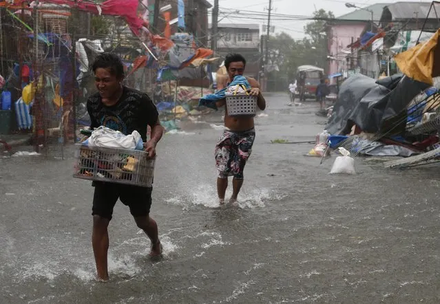 Residents carry their belongings as Typhoon Rammasun (locally named Glenda) hit the town of Imus, Cavite southwest of Manila, July 16, 2014. 
(Photo by Erik De Castro/Reuters)