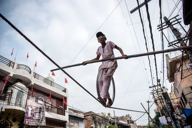Manisha, a young Indian girl entertains people while performing on a Tightrope stunt on August 03, 2017 in New Delhi, India. Her rare skills allow her to take home 1,500 to 2,000 rupees per day for her family but her job on the tightrope leaves little time for schoolwork. (Photo by Ankur Dutta/Barcroft Images)