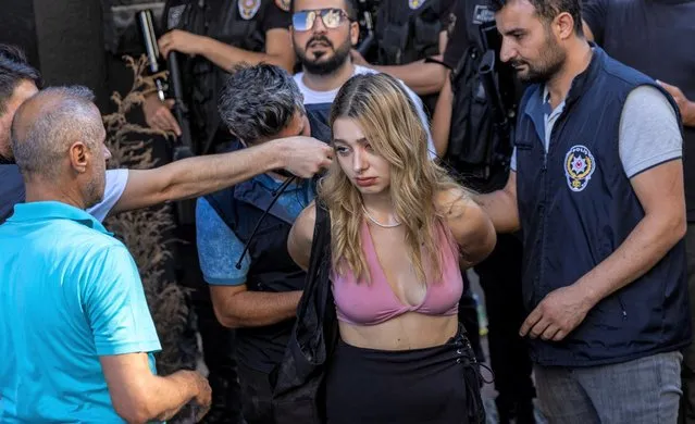 Police officers detain an activist to prevent her from marching in a pride parade, which was banned by local authorities, in central Istanbul, Turkey on June 26, 2022. (Photo by Umit Bektas/Reuters)