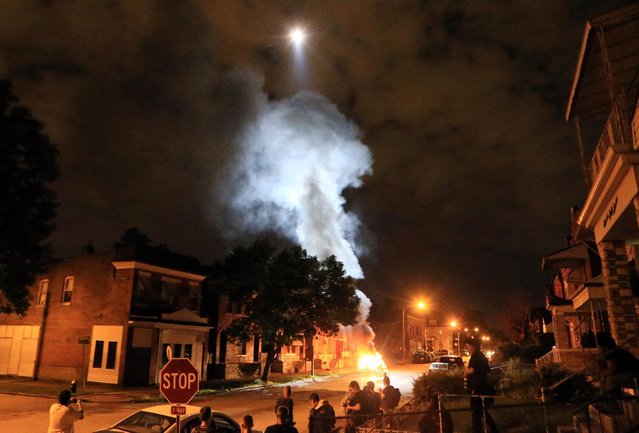 A police helicopter illuminates a burning car Wednesday, August 19, 2015, after it was set ablaze following a fatal officer-involved shooting, in St. Louis. (Photo by Christian Gooden/St. Louis Post-Dispatch via AP Photo)