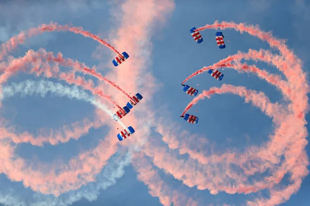 An RAF parachute display team let off smoke canisters as they descend as part of a ceremony for the Queen's Baton Relay for the 2018 Gold Coast Commonwealth Games at Brize Norton, Britain on August 16, 2017. (Photo by Steven Paston/PA Wire)
