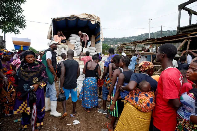 Displaced victims of a flash flood, which came after the mudslide, are seen sharing vegetable oil at a World Food distribution program, at Pentagon, in Freetown, Sierra Leone, August 18, 2017. (Photo by Afolabi Sotunde/Reuters)