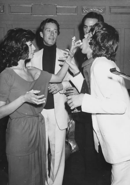 Bianca Jagger feeds cake to husband Mick Jagger as designer Halston looks on during Bianca's birthday bash at Studio 54 on May 3, 1977. (Photo by Richard Corkery/NY Daily News Archive via Getty Images)