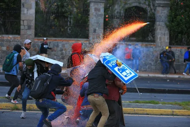 Demonstrators set up barricades to protect themselves during clashes with members of the police around the House of Culture in Quito, Ecuador, 23 June 2022. The center of Quito once again became the scene of intense clashes between the Ecuadorian Police and the demonstrators who, for the eleventh consecutive day, participated in the protests against the high cost of living and the economic policies of the Government of President Guillermo Lasso. (Photo by Jose Jacome/EPA/EFE)