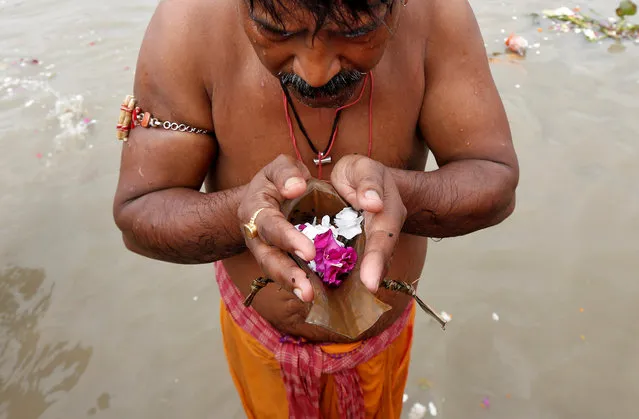 A Hindu man performs Tarpana, a religious ritual, on the banks of the river Ganges to honour the souls of his departed ancestors during the auspicious day of Mahalaya in Kolkata, September 19, 2017. (Photo by Rupak De Chowdhuri/Reuters)