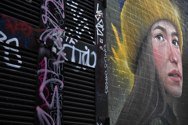 A piece of street art entitled 'Girl in a Ukrainian hat' by WOSKerski is seen on a wall in east London on April 29, 2022. The war in Ukraine has been reflected in street art in various locations around the capital. (Photo by Ben Stansall/AFP Photo)