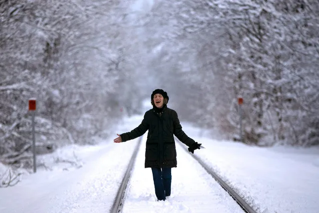 Ellen Werner enjoys the snow-covered landscape following an early spring snowstorm that dumped several inches of heavy, wet snow, Tuesday, March 24, 2020, in Freeport, Maine. Werner, of New York City, is self-quarantining at a condo in Freeport to be near her children. She is not sick but wanted to be out of New York. (Photo by Robert F. Bukaty/AP Photo)