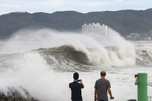 People watch the waves brought by Typhoon Hinnamnor in Ulsan on September 6, 2022, as the typhoon hit South Korea's southern provinces. (Photo by Yonhap via AFP Photo)