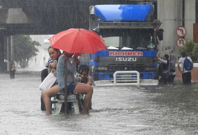 Stranded passengers ride on a improvised pushcart to cross a flooded street during tropical storm Fung-Wong in St Mesa, metro Manila September 19, 2014. (Photo by Erik De Castro/Reuters)