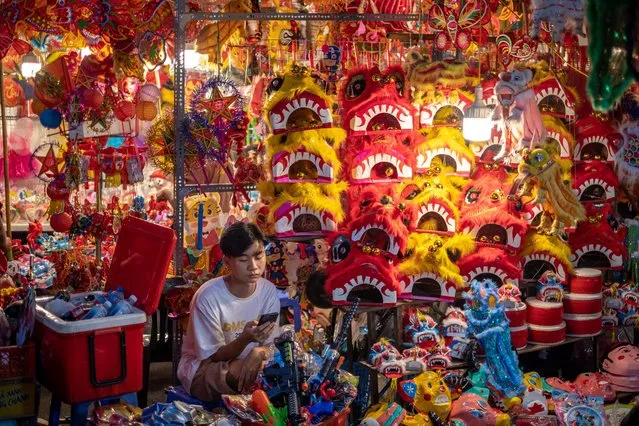 A vendor waits for customers in front of his shop selling Mid-Autumn Festival goods on Hang Ma Street on September 3, 2022 in Hanoi, Vietnam. The ancient Mid-Autumn Festival, which falls on lunar August 15 (September 10 this year), is an occasion for a children night out and family gathering with the customs of moon contemplating, procession of star and moon-shaped lanterns, lion dance, as well as holding parties with moon cakes and fruits. (Photo by Linh Pham/Getty Images)