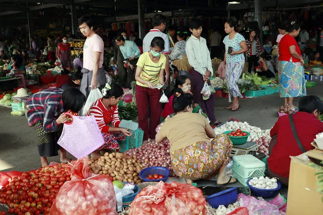People buy foods and other supplies at a local market in Naypyitaw, Myanmar Tuesday, March 24, 2020. Myanmar has announced its first two confirmed cases of COVID-19, one in the nation's biggest city, Yangon, and the other in the western state of Chin. (Photo by Aung Shine Oo/AP Photo)