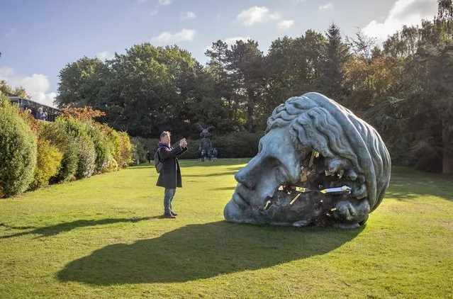 In this image released on Monday 10th October 2022, a man photographs Daniel Arsham's Unearthed Bronze Eroded Melpomene, 2021, during the launch of Relics in the Landscape at Yorkshire Sculpture Park on October 08, 2022 in Wakefield, England. (Photo by Anthony Devlin/Getty Images for Daniel Arsham)
