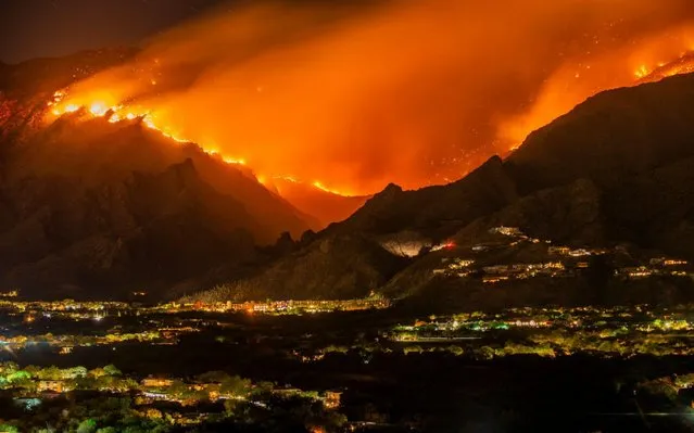 Smoke and flames move down Ventana Canyon toward the Ventana Canyon Resort and million dollar homes perched on the hillside, Tucson, Arizona on June 19, 2020. (Photo by A.T. Willett/Alamy Live News)