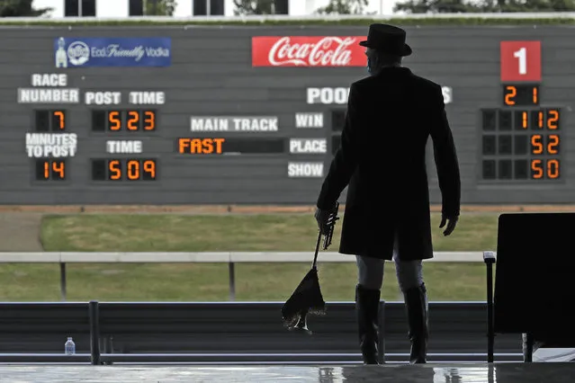 Track bugler Dan Harrington stands near empty seats Wednesday, June 24, 2020, before playing just before a race at Emerald Downs Racetrack in Auburn, Wash., on the first day of thoroughbred horse racing at the track since all professional sports in Washington state were curtailed in March by the outbreak of the coronavirus. No spectators were allowed, but online wagering was available and the races were streamed. Organizers hope to continue racing into October on a modified schedule. (Photo by Ted S. Warren/AP Photo)