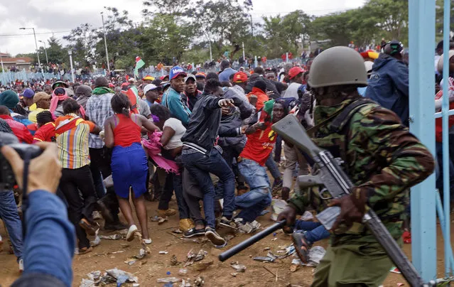Supporters of President Uhuru Kenyatta engage in rock-throwing clashes with police at his inauguration ceremony after trying to storm through gates to get in and being tear-gassed, at Kasarani stadium in Nairobi, Kenya Tuesday, November 28, 2017. (Photo by Ben Curtis/AP Photo)