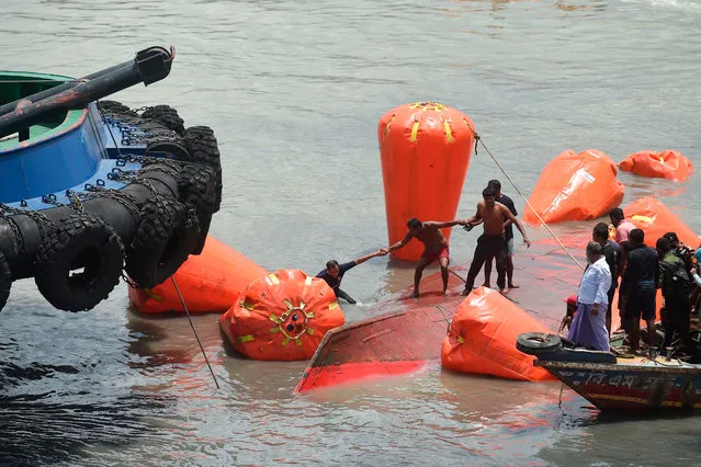 Rescue and fire service personnel carry on rescue works the day after a ferry capsized in the Buriganga River in Dhaka on June 30, 2020. At least 32 people died after a ferry capsized and sank on June 29 in the Bangladeshi capital Dhaka following a collision, said rescuers, who found one man alive in a “miracle” hours later. A dozen people were initially listed as missing. (Photo by Munir Uz Zaman/AFP Photo)