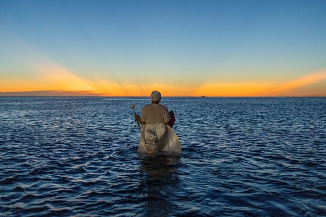 A woman wades into the waters of Ramirez Beach as part of a ritual honoring the African sea goddess Yemanja, in Montevideo, Uruguay, Sunday, February 2, 2025. (Photo by Matilde Campodonico/AP Photo)