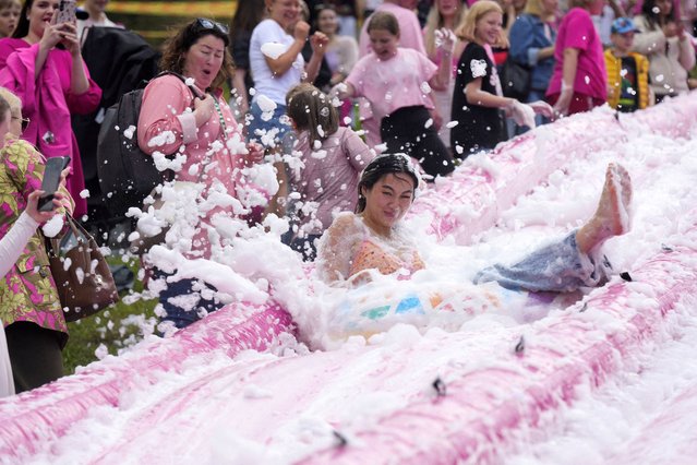A woman enjoys sliding down the 50-meter-long pink slide during the Pink Soup Fest in Vilnius, Lithuania on May 31, 2025. (Photo by Ints Kalnins/Reuters)
