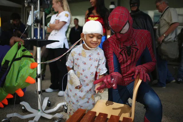 Mattel Children's Hospital UCLA patient Gael Martin, 5, (L) meets a window washer dressed as Spider-Man in Los Angeles, California, September 14, 2016. (Photo by Lucy Nicholson/Reuters)