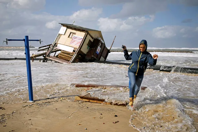 A woman runs away from a wave next to a lifeguard tower that collapsed during a storm, in the Mediterranean coast of the city of Ashkelon, Israel January 19, 2018. (Photo by Amir Cohen/Reuters)