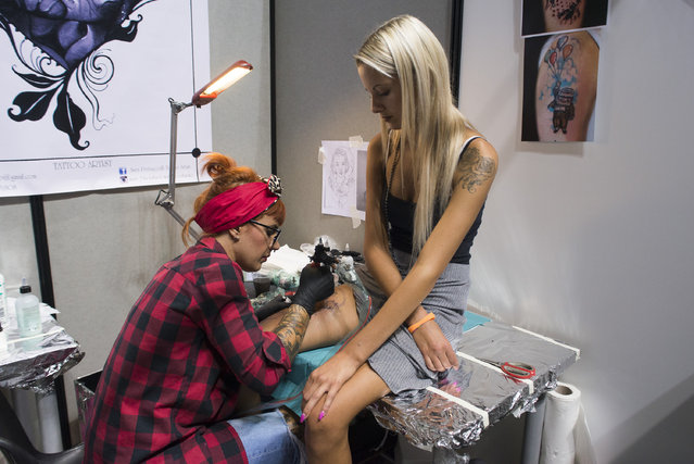 A tattoo artist applying ink on a girl's thigh at the 2016 Italian Tattoo Artists at the Palavela on September 17, 2016 in Turin, Italy. (Photo by Stefano Guidi/ZUMA Press/Splash News)