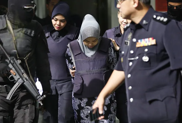 Indonesian Siti Aisyah, center, is escorted by police as she leaves after a court hearing at Shah Alam court house in Shah Alam, Malaysia, Monday, January 29, 2018. Siti Aisyah and Doan Thi Huong of Vietnam pleaded not guilty to killing Kim Jong Nam, the estranged half brother of North Korean leader Kim Jong Un, last Feb. 13 in a crowded Kuala Lumpur airport terminal. They are accused of smearing VX nerve agent on Kim Jong Nam's face. (Photo by Sadiq Asyraf/AP Photo)