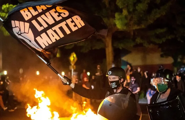 Protesters gather in front of a fire near the North police precinct during a protest against racial injustice and police brutality on September 6, 2020 in Portland, Oregon. Sunday marked the 101st consecutive night of protests in Portland. (Photo by Nathan Howard/Getty Images)