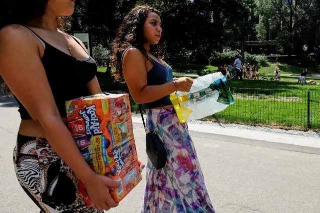 People carry beverages to cool off during a hot and sunny day at Central Park in New York, U.S., July 17, 2016. (Photo by Eduardo Munoz/Reuters)