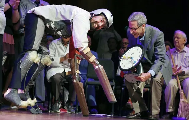 Thomas Thwaites, left, accepts the Ig Nobel prize in biology from Nobel laureate Eric Maskin (economics, 2007) during ceremonies at Harvard University in Cambridge, Mass., Thursday, September 22, 2016. Thwaites, of the United Kingdom, won for creating prosthetic extensions of his limbs that allowed him to move like and to roam in the company of goats. (Photo by Michael Dwyer/AP Photo)