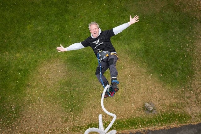 A visitor takes a leap from a 50-metre crane at Coram’s Fields in central London on June 25, 2025, where new electric car brand Leapmotor is offering free bungee jumps alongside test drives in an usual marketing ploy. (Photo by Will Ireland/South West News Service)