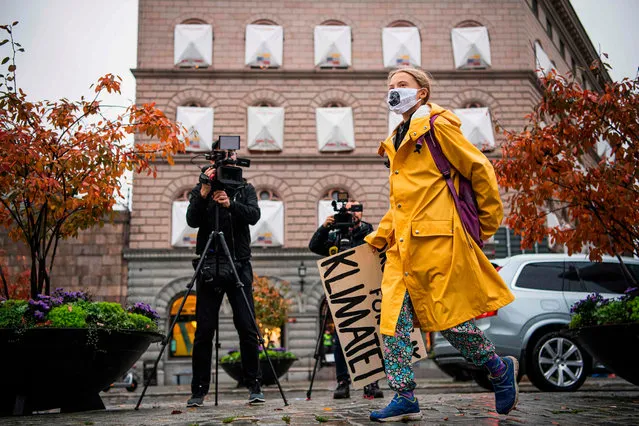 Swedish climate activist Greta Thunberg arrives with her placard reading “School strike for climate” to stage a Fridays for Future protest in front of the Swedish Parliament Riksdagen in Stockholm on October 9, 2020. (Photo by Jonathan Nackstrand/AFP Photo)