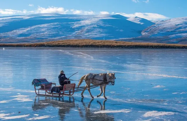 A man enjoys horse-drawn sleigh on the partially frozen Lake Cildir during winter in Kars, Turkiye on January 11, 2023. (Photo by Ismail Kaplan/Anadolu Agency via Getty Images)