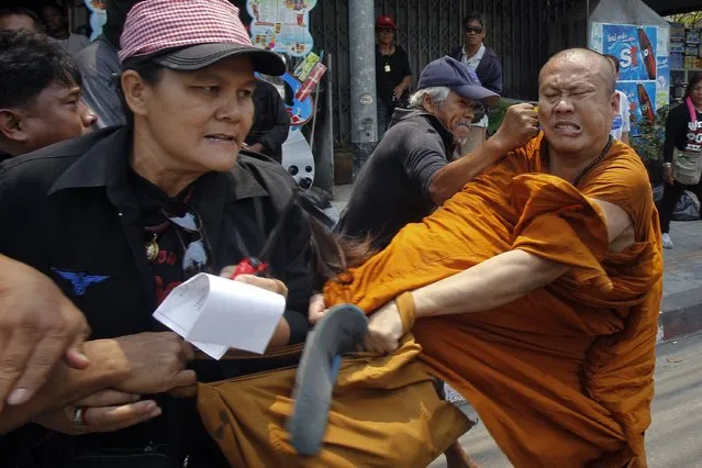 Members of the pro-government “red shirt” movement attack a Buddhist monk outside the National Anti-Corruption Commission office in Nonthaburi province, on the outskirts of Bangkok, in this March 24, 2014 file photo. (Photo by Chaiwat Subprasom/Reuters)