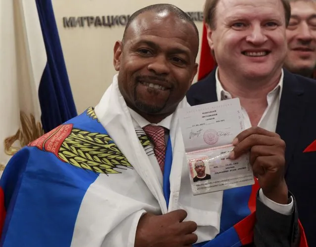 U.S. boxer Roy Jones Jr. shows his passport at the Russian Federal Migration Service branch in Moscow, Russia, October 27, 2015. Jones received a new Russian passport on Tuesday after President Vladimir Putin signed a decree to grant him the Russian citizenship, local media reported. (Photo by Boris Ivanov/Reuters)