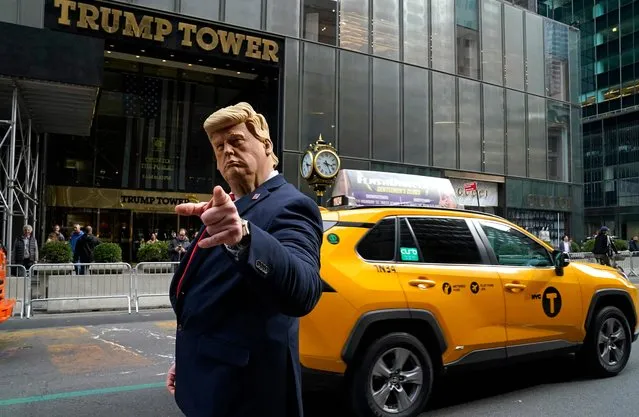 Former US President Donald Trump's impersonator Neil Greenfield gestures outside Trump Tower in New York City on March 22, 2023. With barricades set up near Trump Tower and police on high alert, New York was holding its breath March 22, 2023 for the likely indictment of Donald Trump, but the timing remained uncertain. (Photo by Timothy A. Clary/AFP Photo)