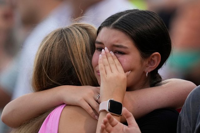 Girls hug during a vigil for flooding victims at Tivy Antler Stadium on Wednesday, July 9, 2025, in Kerrville, Texas. (Photo by Ashley Landis/AP Photo)