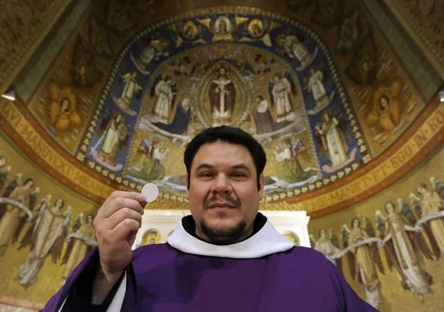 Father Macario Martinez holds a low-gluten alter bread in the chapel of the Benedictine Sisters of Perpetual Adoration monastery in Clyde, Missouri, December 18, 2014. (Photo by Dave Kaup/Reuters)