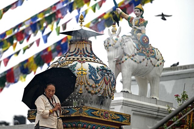 A Buddhist devotee offers prayers at Boudhanath Stupa in Kathmandu on September 18, 2025. (Photo by Arun Sankar/AFP Photo)