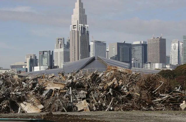 Skyscrapers soar above the roof of the Tokyo Metropolitan Gymnasium as the rubble of Japan's National Stadium demolished for the renovation for the 2020 Olympic games is collected at one corner of the vacant site shown to the media for the first time after the completion of the demolition work in Tokyo Monday, Nov. 16, 2015. (Photo by Koji Sasahara/AP Photo)