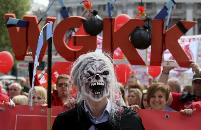 A participant of the traditional May Day celebrations, organized by the Austrian Social Democrats, SPOE, and trade unions wearing a horror mask in Vienna, Austria, May 1, 2018. (Photo by Ronald Zak/AP Photo)
