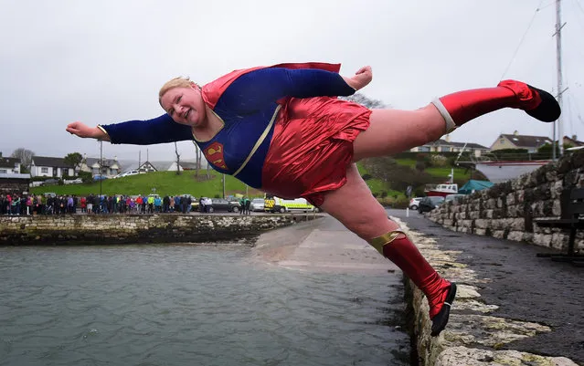 Angela McClements takes the plunge as swimmers brave the icy waters during the New Year's Day swim at Carnlough harbour on January 1, 2015 in Carnlough, Northern Ireland. The annual event on the north Antrim coast supports Spina Bifida and Hydrocephalus charities. (Photo by Charles McQuillan/Getty Images)