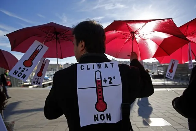 Environmental activists hold red umbrellas as they take part in a symbolic human chain gathering, after the cancellation of a planned climate march following shootings in the French capital, ahead of the World Climate Change Conference 2015 (COP21), in Marseille, France, November 29, 2015. (Photo by Jean-Paul Pelissier/Reuters)