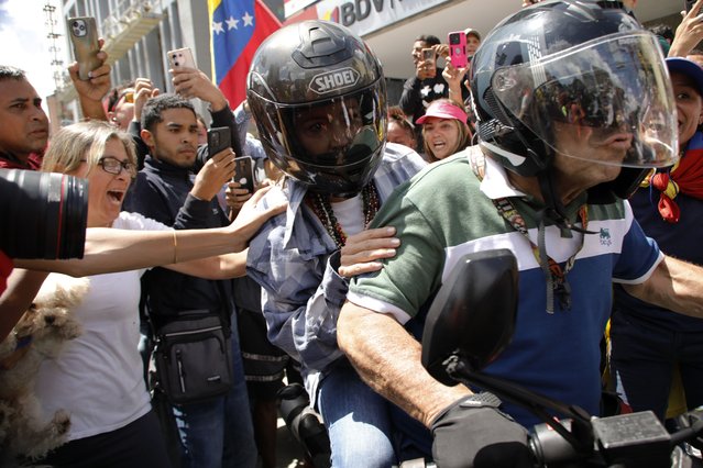 Opposition leader Maria Corina Machado is driven away on a motorbike at the end of a rally in Caracas, Venezuela, Saturday, August 3, 2024. (Photo by Cristian Hernandez/AP Photo)