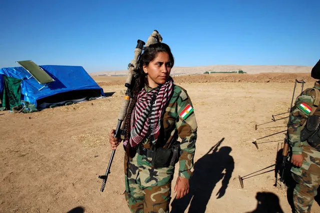 An Iranian-Kurdish female fighter carries her weapon during a battle with Islamic State militants in Bashiqa, near Mosul, Iraq on November 3, 2016. (Photo by Ahmed Jadallah/Reuters)