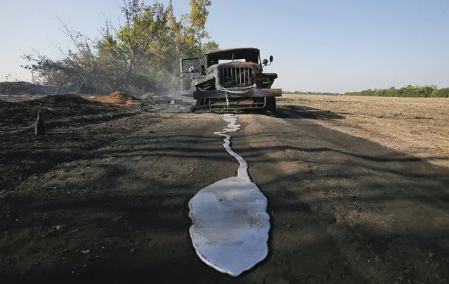 A puddle of melted material is pictured in front of a burnt truck belonging to Ukrainian forces on a road near the village of Berezove, southwest from Donetsk, September 4, 2014. (Photo by Maxim Shemetov/Reuters)