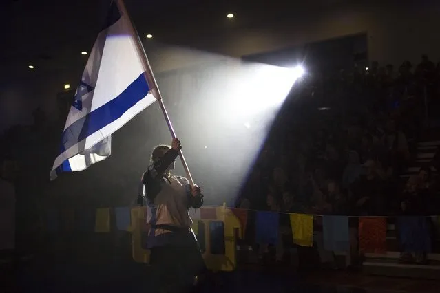 Ira Rogozovsky from the Israeli team carries the national flag during the “World Medieval Fighting Championship – the Israeli Challenge” in Rishon Letzion near Tel Aviv on January 22, 2015. (Photo by Amir Cohen/Reuters)